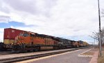 An eastbound BNSF freight with some foreign power passes the Amtrak Depot